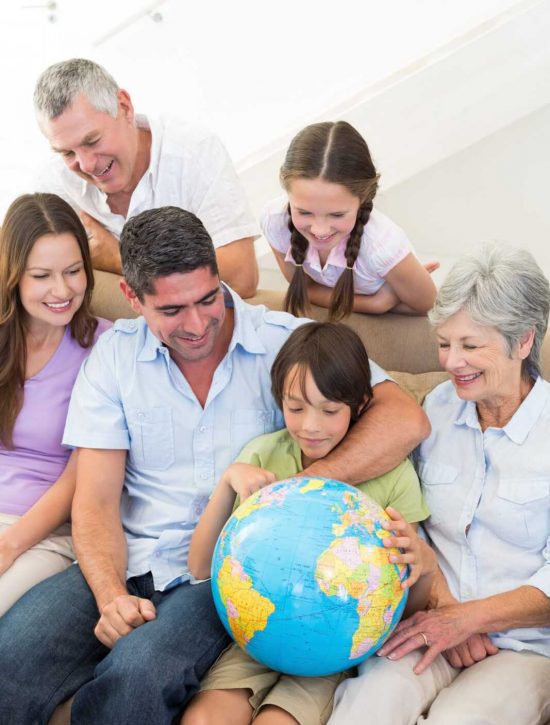 Multigeneration family looking at globe in house